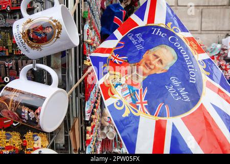 London, UK. 27th Apr, 2023. In central London stalls sell souvenirs for tourists which commemorate the upcoming coronation of King Charles III. from bags and flags to mugs and cuddly toys, it is hoped that the coronation will bring an influx of tourists and a boost to the economy. Credit: Anna Watson/Alamy Live News Stock Photo