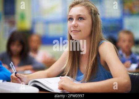 Remembering the formula. A young girl working on her schoolwork in class Stock Photo