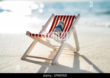 Rolled Up Bundle Of Fifty Dollar Banknotes On Miniature Deck Chair At Beach Stock Photo