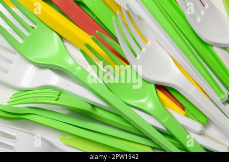 Pile of bright yellow, green and white used plastic kitchenware appliances. Ecological problem. Plastic pollution Stock Photo