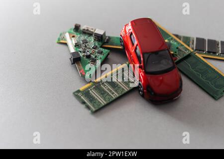Toy cars on an electronic board with integrated circuits. The shortage of microchips and semiconductors creates a shortage of new cars. semiconductor Stock Photo