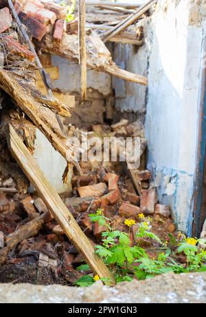 Old abandoned one-story house in disrepair. Collapsed walls Stock Photo