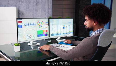 African Data Analyst Man Using Spreadsheet On Computer Stock Photo
