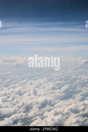 Cumulus clouds on blue sky seen from above. Cloudscape at high altitude. Heaven, flying, freedom concept. Stock Photo