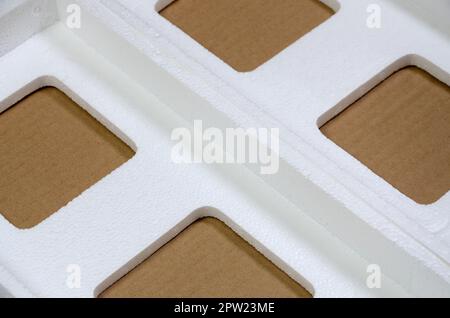 Background image with beige cardboard paper and styrofoam boxes disgarded as rubbish. The concept of unpacking new home appliances out of the carton b Stock Photo