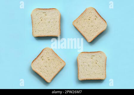 A few pieces of bread lies on texture background of fashion pastel blue color paper in minimal concept. Stock Photo