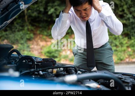 Asian businessman car broken breakdown, young stressed man having trouble car failure problem looking in frustration at failed engine in the morning, Stock Photo