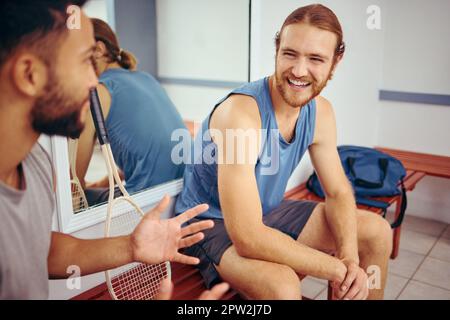 Cheerful friends talking in the gym. Happy players bonding and talking in a locker room. Men talking and relaxing before a match. Two athletes sitting Stock Photo