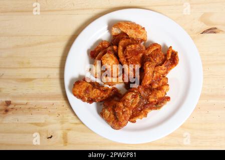 Fried Pork Skins With Red Salsa in Plate on Table Stock Photo
