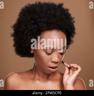 Face, hair and split ends with a model black woman in studio on a brown background with haircare issues. Stress, salon and hair care with an attractiv Stock Photo