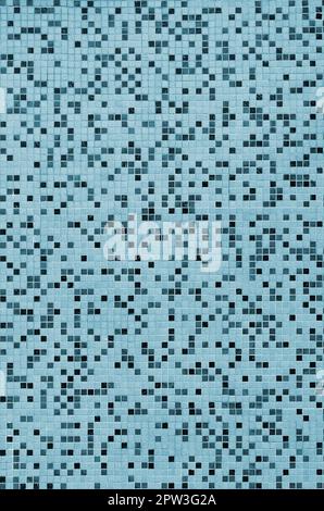 The texture of the wall, decorated with a mosaic of various small square tiles. Abstract pattern of ceramic tiles on the wall Stock Photo