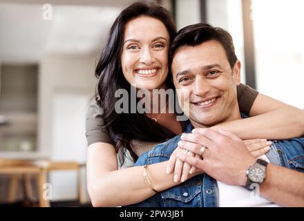 Home gives us the brightest smiles. a happy young couple embracing at home. Stock Photo