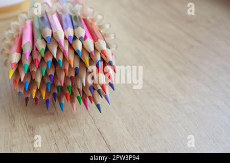 A lot of sharply sharpened colored pencils on a wooden table. Stock Photo