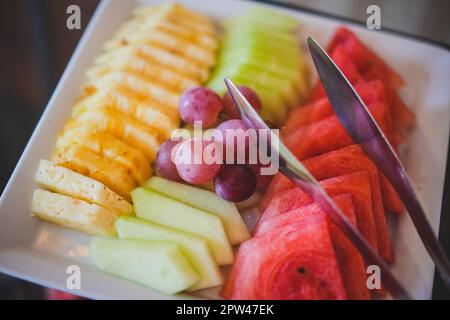 Sliced fruit mix on a plate, orange, watermelon, grape. Stock Photo