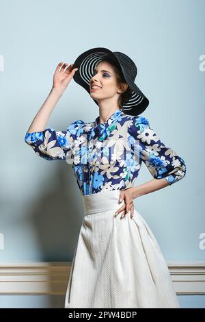 Portrait of beautiful girl in black broad brim hat blue blouse and white skirt with buttons in stiletos Stock Photo Alamy