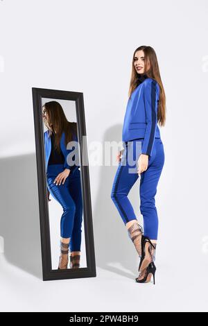 Cute girl in pantsuit and tulle socks near the mirror Stock Photo - Alamy