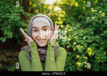 Beautiful joyful teen high school girl wearing colorful muslim clothing having fun outdoors Stock Photo