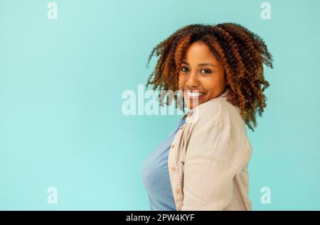 Cheerful good looking carefree young african american woman showing calm down, assure all fine and smiling, standing blue background satisfied. Happy Stock Photo