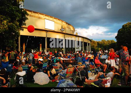 An audience and crowd arranges lawn chairs and blankets on the grass outside the theater at Tanglewood to hear a classical music concert Stock Photo