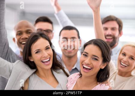 Weve made it to the big time. a group of businesspeople smiling and raising their hands Stock Photo