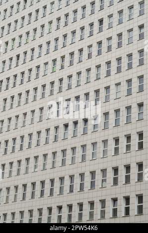 A pattern of many windows from a multi-storey office building. A large number of plastic windows in the wall of a modern multi-storey building Stock Photo