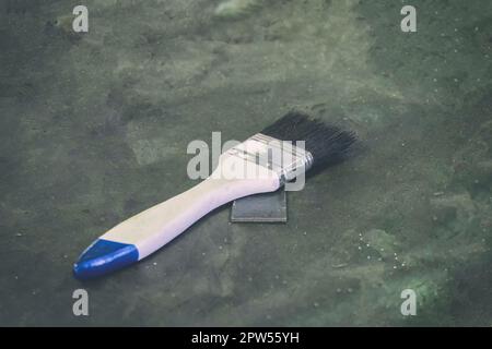White paint brush on the gray-black cement floor Stock Photo