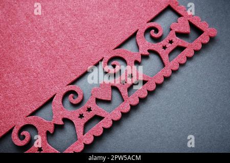 Background New Year's or for Valentine's Day. Kissing goats with stars and hearts are carved on red felt fabric. Merry Christmas and Happy New Year. P Stock Photo