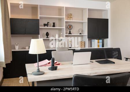 Comfortable office chair near wooden table with laptop computer, Interior of an office desk workspace room, empty no body Stock Photo