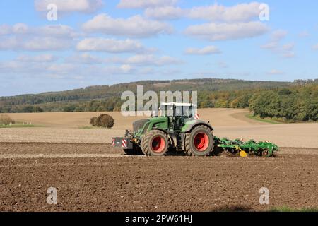 Landwirt eggt mit seinem Traktor ein Feld nahe der Sababurg, Hessen, Deutschland, Hofgeismar Stock Photo
