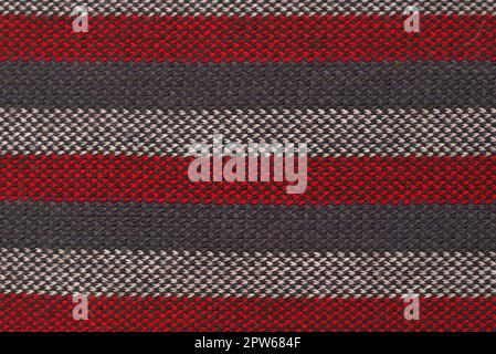Texture close up of a red, gray and white striped wool cloth. The volume and texture of the threads can be clearly seen. Stock Photo