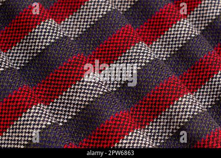 Studio shot of a folded red, gray and white striped scarf. The wavy volume and texture of the threads can be clearly seen. Stock Photo