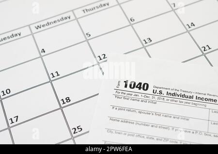 IRS Form 1040 Individual Income Tax Return blank lies on empty calendar page. Tax period concept. Copy space for text Stock Photo
