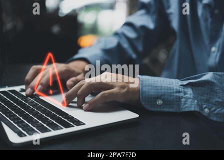 Businessman programmer, developer using laptop computer with triangle caution warning sign for notification error and maintenance concept. Stock Photo