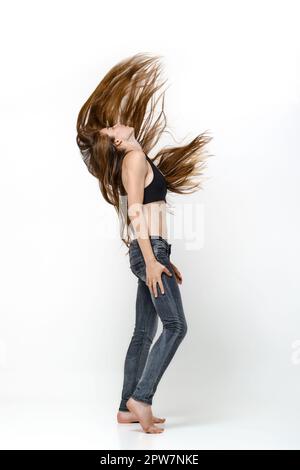 Full lehgth portrait of barefoot young woman shaking long hair Stock Photo