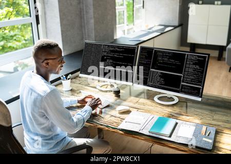 African American Coder Using Computer At Desk. Web Developer Stock Photo