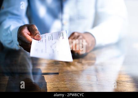 African Business Man Giving Paycheck Or Payroll Cheque Stock Photo