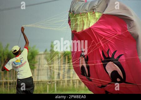 A participant is flying a balloon kite during the 2004 Jakarta International Kite Festival that held on July 9-11 at Karnaval (Carnival) Beach in Ancol Dreamland, North Jakarta, Jakarta, Indonesia. Stock Photo