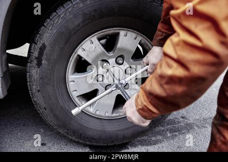 Car mechanic tighten car wheel nuts with wrench in workshop in Odessa Ukraine Stock Photo