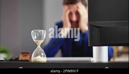 Late Invoice And Billing Deadline With Hourglass At Desk Stock Photo