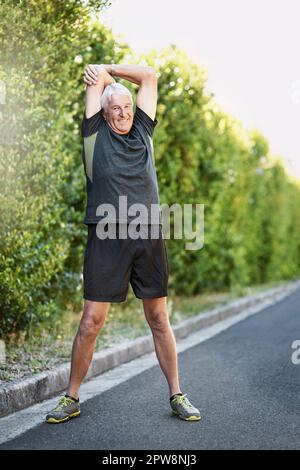 Ive got stretches to warmup and cool down. Portrait of a senior man warming up before a run outside. Stock Photo