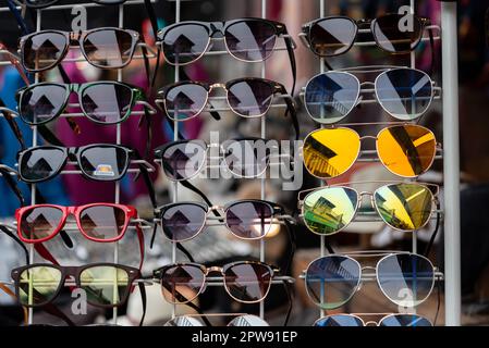Range of different coloured and shapes of sunglasses on display near the seaside in Brighton, England. Stock Photo