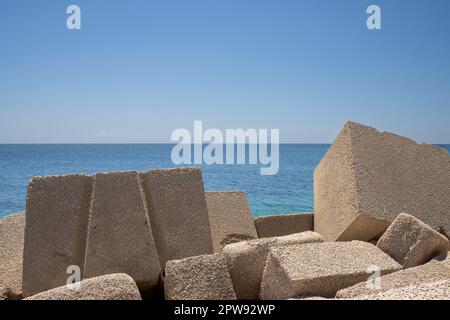 Huge cubic objects, made of concrete, used as a seawall in local marina ...