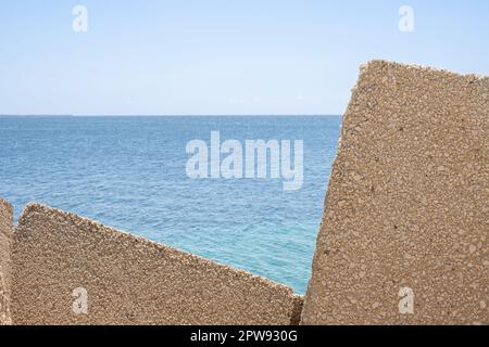 Huge cubic objects, made of concrete, used as a seawall in local marina ...