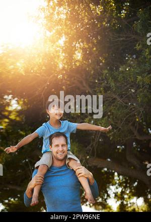 Riding high on dads shoulders. Portrait of a father and his young son spending quality time together outside. Stock Photo