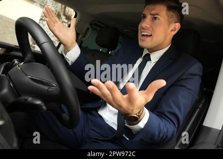 Emotional man in car. Aggressive driving behavior Stock Photo