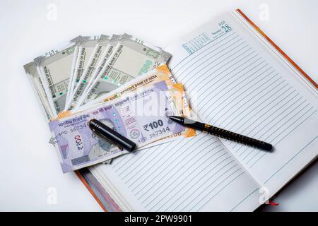 Budget concept. Indian money with pen in open notebook on white background. Stock Photo