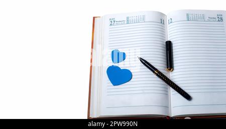 Love concept. Notebook with pen and blue hearts isolated on white background. Stock Photo