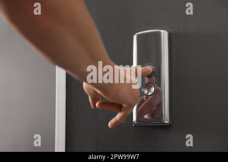 Man pressing elevator call button, closeup view Stock Photo