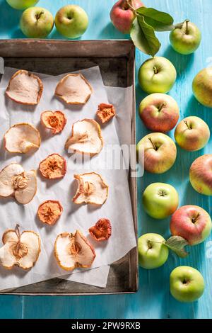 Homemade and sweet dried apples on old baking tray. Dried fruits in the sun in the garden. Stock Photo