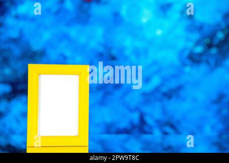 front view yellow picture frame on light blue background portrait photo color shoot present gift picture Stock Photo